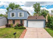 Charming two-story home with blue siding, brick accents, attached garage, and well-maintained landscaping at 3916 S Telluride Ct, Aurora, CO 80013