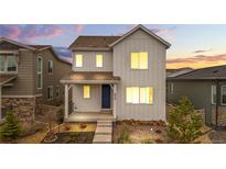 Charming two-story home featuring modern design, landscaped yard, and a welcoming front porch with a blue front door at 8028 Williams Fork Ave, Littleton, CO 80125