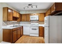 Traditional kitchen featuring wood cabinets, white appliances, and neutral countertops at 745 S Alton Way # 9B, Denver, CO 80247