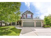 Charming two-story home featuring a three-car garage and beautifully landscaped front yard with mature trees at 5686 Brook Hollow Dr, Broomfield, CO 80020