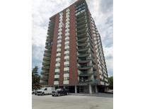 Brick high-rise building with balconies and ample parking at 550 E 12Th Ave # 1501, Denver, CO 80203