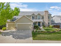 Inviting two-story home boasts a manicured lawn, three-car garage, and charming stone accents, perfect for suburban living at 7837 Aravon Ct, Lone Tree, CO 80124