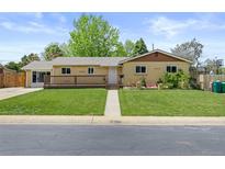 Lovely ranch-style home with well-manicured lawn, mature shade trees, and covered porch at 1195 S Kendall St, Lakewood, CO 80232