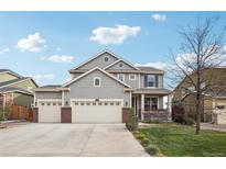 Charming two-story home with a three car garage, inviting porch, and well-maintained landscaping at 5362 E 140Th Pl, Thornton, CO 80602