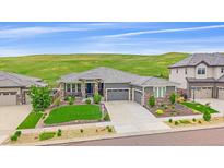 Beautiful single-Gathering home featuring a three-car garage and manicured landscaping with natural backdrop at 9433 Torrey Way, Arvada, CO 80007