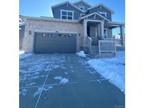 Two-story house with gray siding, stone accents, and a three-car garage at 24704 E Pacific Pl, Aurora, CO 80018