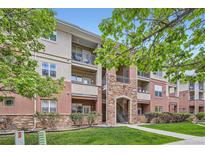 Beautiful condo building with stone accents, balconies, and lush landscaping at 8083 W 51St Pl # 203, Arvada, CO 80002