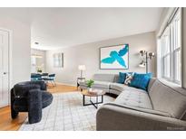 Bright living room with hardwood floors, gray sectional, and modern decor at 6002 E 29Th Ave, Denver, CO 80207