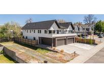 Modern two-story home featuring a brick facade, black trim, two-car garage, and a concrete driveway at 5240 N Raleigh St, Denver, CO 80212