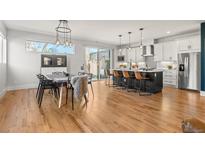 Spacious open floor plan with kitchen island, modern lighting, and dining area at 5240 N Raleigh St, Denver, CO 80212