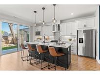 Modern kitchen featuring a large island, stainless steel appliances, and ample counter space at 5240 N Raleigh St, Denver, CO 80212