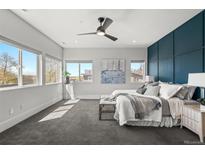 Sun-filled main bedroom featuring a ceiling fan, neutral color palette, carpet, and views from multiple windows at 5240 N Raleigh St, Denver, CO 80212
