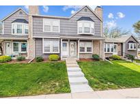 Charming townhouse featuring a well-manicured lawn, brick accents and steps leading to the front entrance at 17108 E Whitaker Dr # B, Aurora, CO 80015