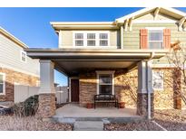 Charming covered front porch with stone accents and cozy seating area at 9139 W 104Th Cir, Westminster, CO 80021