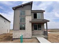 Modern two-story home showcasing a blend of gray siding and stone accents, enhancing its curb appeal at 24251 E 54Th Pl, Aurora, CO 80019