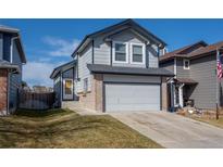 Charming two-story home with gray siding, brick accents, and a two-car garage on a sunny day at 8819 Cloverleaf Cir, Parker, CO 80134
