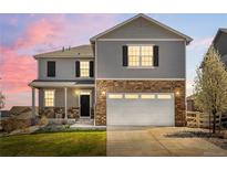 Charming two-story home with stone accents, a two-car garage, and a well-manicured lawn at 6024 High Timber Cir, Castle Rock, CO 80104