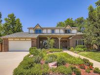 Beautiful brick two-story home with a lush front yard and inviting entry way at 9931 E Ida Pl, Greenwood Village, CO 80111