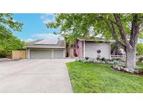 Charming home featuring a well-manicured lawn, mature trees, and a welcoming driveway leading to a spacious garage at 7567 Parkview Mtn, Littleton, CO 80127