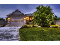 Charming single Gathering home featuring manicured lawn, stone accents, and an attached garage at 6652 W Asbury Pl, Lakewood, CO 80227