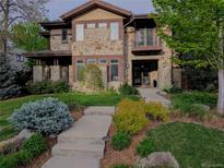 Stunning stone home with manicured lawn and landscaping offers timeless elegance and curb appeal at 230 Hudson St, Denver, CO 80220