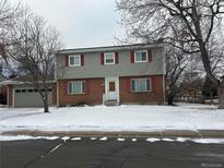 Charming two-story home featuring red shutters and a brick facade with a snow-covered front yard at 856 E Costilla Way, Centennial, CO 80122