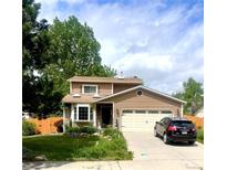 Charming two-story home features a manicured lawn, two car garage, and beautiful landscaping at 6687 Devinney Ct, Arvada, CO 80004