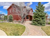 Beautiful two-story home featuring a brick walkway, mature landscaping, and a covered porch at 7999 S Blackstone Pkwy, Aurora, CO 80016