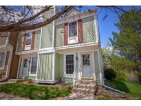 Charming townhome featuring a light green exterior, red shutters and well-maintained landscaping at 10735 W Dartmouth Ave, Lakewood, CO 80227