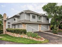 Charming home features a stone accents, two-car garage, and manicured landscaping at 185 Players Club Dr, Castle Rock, CO 80104