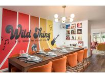 Fun dining room featuring colorful accent wall and space for large gatherings at 7039 Otis Ct, Arvada, CO 80003