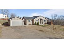 Charming single-Gathering home featuring a detached garage and a spacious front yard at 3230 S Decatur St, Denver, CO 80236