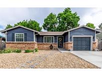 Charming single-story home with a brick foundation, blue siding, and a well-manicured front yard at 8696 W 86Th Cir, Arvada, CO 80005