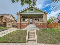 Charming brick bungalow featuring a covered porch and well-maintained front yard at 1615 Osceola St, Denver, CO 80204