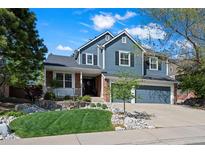 Charming two-story home with a well-maintained lawn, rock features, and an attached two-car garage at 1113 Southbury Pl, Highlands Ranch, CO 80129