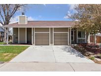 Charming home featuring a two-car garage and a well-maintained lawn and a clean concrete driveway at 15427 E Oberlin Pl, Aurora, CO 80013