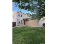 Charming two-story home featuring a lush green lawn, neutral siding, and a brick facade at 18897 E Linvale Pl, Aurora, CO 80013
