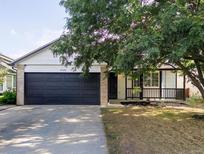 Charming single-story home with a dark two-car garage and a welcoming front porch at 14608 E 52Nd Ave, Denver, CO 80239