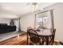 Cozy dining area featuring wood floors, a ceiling fan, and a view to the living room at 2201 Sable Blvd # 1008, Aurora, CO 80011