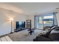 Inviting living room with a TV, comfortable seating, and access to a balcony at 2201 Sable Blvd # 1008, Aurora, CO 80011