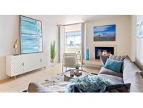 Bright living room featuring modern decor, fireplace, and balcony access with city views at 1313 N Williams St # 1103, Denver, CO 80218