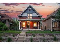 Charming home with a covered porch and a beautifully landscaped front yard at sunset at 3008 N York St, Denver, CO 80205