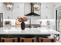 Modern kitchen boasts a large island, updated appliances, and stylish black accents at 3008 N York St, Denver, CO 80205