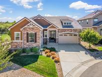 Charming home featuring stone accents, a manicured lawn, and a two-car garage at 6999 S Tempe Ct, Aurora, CO 80016