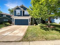 Charming two-story home with a well-maintained lawn and a deep blue two car garage at 5005 W 128Th Pl, Broomfield, CO 80020