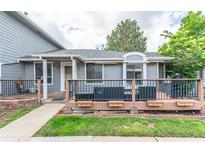 Charming gray home featuring a welcoming front porch with room for seating and a grill at 7925 York St # 2, Denver, CO 80229