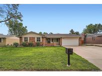 Charming brick home featuring a well-manicured lawn and an attached two-car garage at 678 S Oswego Ct, Aurora, CO 80012
