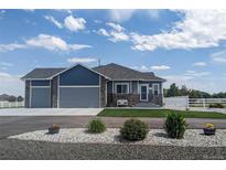 Charming one-story home with a well-manicured front yard, rock garden and a two-car garage at 10610 E 167Th Pl, Brighton, CO 80602