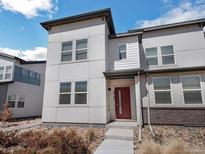 Stylish two-story home featuring a modern design with large windows and a welcoming red front door at 19197 E 64Th Ave, Denver, CO 80249