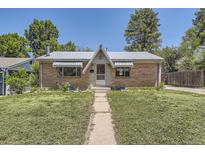 Charming brick home with a metal roof, awnings, and a quaint front yard at 1750 S Dale Ct, Denver, CO 80219